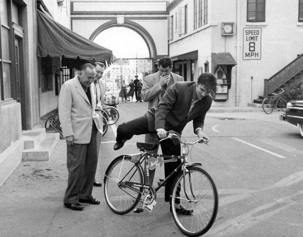 Elvis Presley in LA riding on bicycle at Paramount Studios